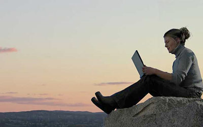 Woman studying on laptop in nature