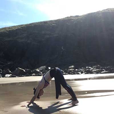 Adhomukha svanasana on the beach in cornwall